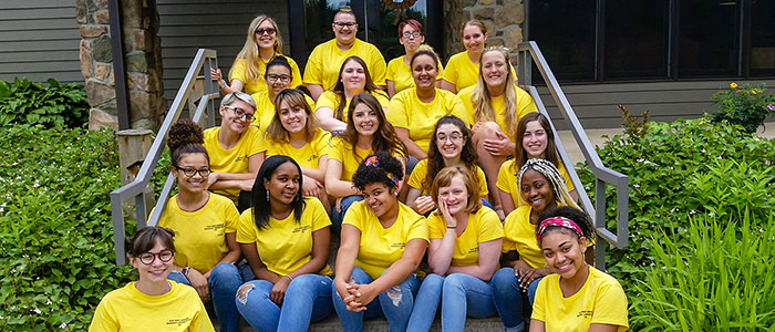 Twenty female students sitting on steps
