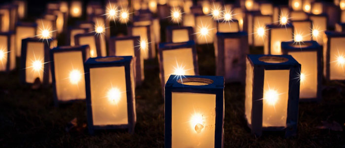 Small candle lite lanterns in the grass
